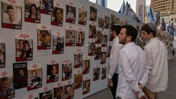 Israelis betrachten Fotos von Menschen, die im Gazastreifen vermisst und gefangen gehalten werden (20.10.2022).