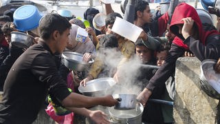 Menschen in Rafah stehen für Lebensmittel an.