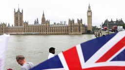 House of Parliament und die britische Fahne im Vordergrund. Symbolbild