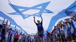 Israel: Demonstrierende gegen die Justizreform versammeln sich unter einer großen Israel-Fahne (24.07.2023)