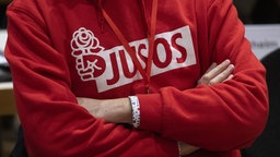 Eine Person trägt einen Kapuzenpullover mit der Aufschrift "JUSOS". Symbolbild