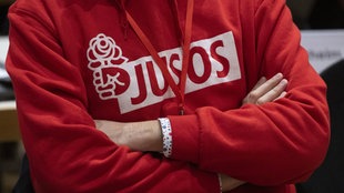 Eine Person trägt einen Kapuzenpullover mit der Aufschrift "JUSOS". Symbolbild