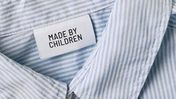Symbolbild: Auf einem Kleidungsetikett steht "Made by Children"