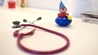 Ein Stethoskop liegt neben einem Kinderspielzeug