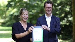 Mona Neubaur, Vorsitzende der Grünen und Ministerpräsident Hendrik Wüst (CDU) halten Koalitionsvertrag, NRW, 23.06.2022