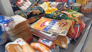 Lebensmittel liegen auf einem Kassenband im Supermarkt. 
