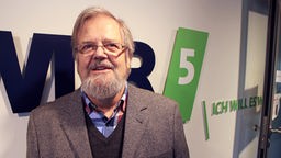 Lutz Beisel vor WDR 5 Logo