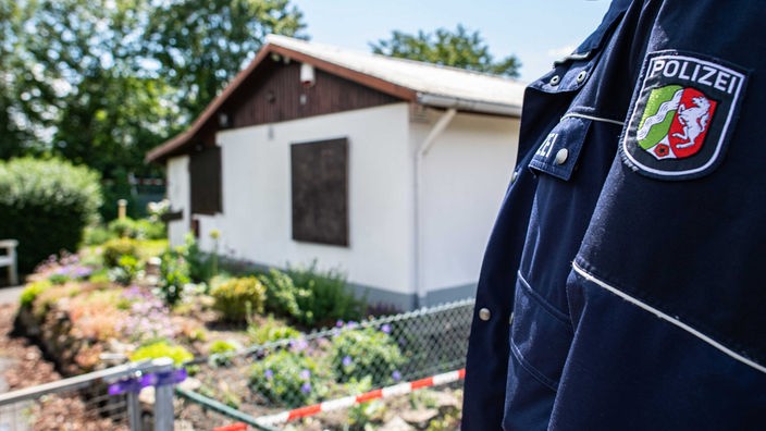  Bei den Ermittlungen nach schwerem sexuellem Missbrauch von Kindern steht ein Polizeibeamter vor der Gartenlaube, wo der vermutliche Haupttäter Teile seiner Server-Anlage unterbrachte (06.06.2020)