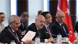 Delegierte der Türkei sitzen am Tisch bei einem NATO-Treffen