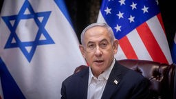Benjamin Netanjahu vor den Fahnen Israels und der USA (2023).