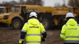  Zwei Mitarbeiter der Firma Northvolt gehen über eine Baustelle. Hier soll die Northvolt-Batteriefabrik für Elektroautos entstehen.