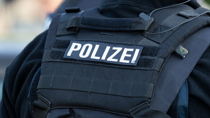 Symbolfoto: Mensch in Uniform mit der Aufschrift "Polizei"