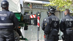  Polizeikräfte sichern im Rahmen einer Razzia Beweismittel (03.05.2023).