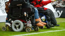 Rollstuhlfahrer am Spielfeldrand eines Fußballstadions. Symbolbild