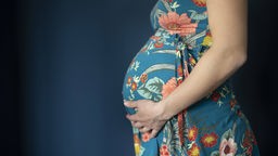 Schwangere Frau hält ihren Bauch 