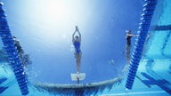 Schwimmerinnen vor dem Absprung von unter Wasser fotografiert