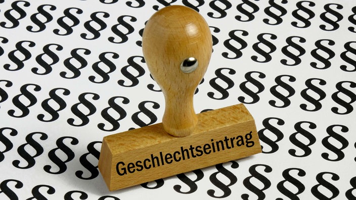 Symbolbild: Ein Stempel mit der Aufschrift "Geschlechtseintrag" auf Paragraphen-Zeichen.