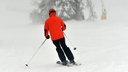 Skifahrer auf einer verschneiten Piste im Nebel. Symbolbild