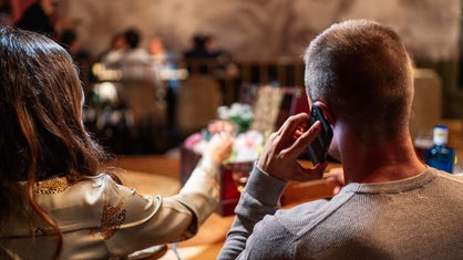 Symbolbild: Mensch mit Smartphone in einem Restaurant