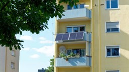 Symbolbild: Mehrfamilienhaus mit Photovoltaikelementen an einem der Balkone