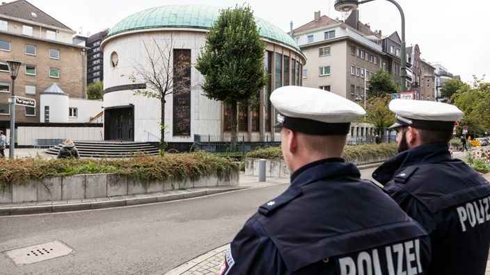 Zwei Polizisten stehen am 10.10.2019 vor der Synagoge in Düsseldorf. 