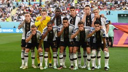 Die deutsche Nationalmannschaft hält sich beim Teamfoto vor ihrem ersten WM-Spiel in Katar den Mund zu (23.11.2022)