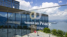 Logo der Friedenskonferenz für die Ukraine auf einem Glasgeländer am Bürgenstock Resort in der Schweiz
