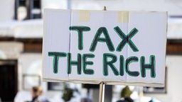 Auf einem Schild steht "Tax the rich". Symbolbild, Archivbild: 14.01.2024