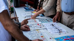 Wahlen in der Türkei. Menschen prüfen Wahlzettel.