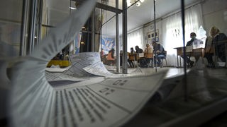 Stimmzettel in einer Wahlurne, Archivbild: 27.09.2022 Scheinreferenden in russisch besetzten Gebieten