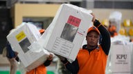 Arbeiter tragen Wahlurnen für die Wahlen am 14. Februar in einem Stadion in Jakarta (13.02.2024).