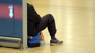 Symbolfoto: Eine Person sitzt wartend auf dem Boden eines Bahnhofs (Streik 2014)