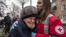  Eine Frau weint in den Armen einer Rettungskraft, Archivbild: 16.12.2022