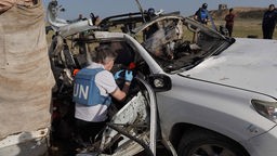 Mitarbeitende der Vereinten Nationen untersuchen das Wrack eines Autos der Hilfsorganisation World Central Kitchen, das durch das israelische Militär zerstört wurde, Archivbild: 02.04.2024