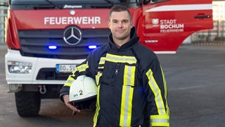 Feuerwehrmann Jörg vor einem Löschzug