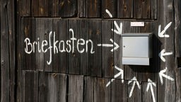 Ein Briefkasten auf einer Holzwand mit der Aufschrift "Briefkasten".