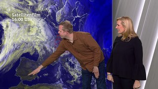 Daniel Schlipf und Claudia Kleinert vor einer Wetterkarte im Studio des HR