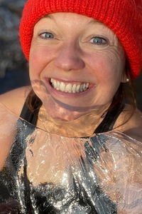 Anita Horn beim Eisbaden grinsend ihm Badeanzug mit einer roten und einem Stück Eis in der Hand