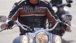 Mann sitzt auf einer Harley Davidson. 