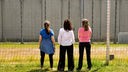 Drei Frauen stehen vor einer Mauer