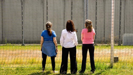 Drei Frauen stehen vor einer Mauer