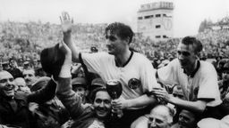 Fritz Walter und  Horst Eckel werden auf den Schultern getragen, nachdem das Team in Bern 1954 Weltmeister geworden ist. 