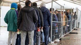 In der Landeserstaufnahmestelle (LEA) warten am 16.11.2022 Flüchtlinge in einer Schlange vor der Essensausgabe.