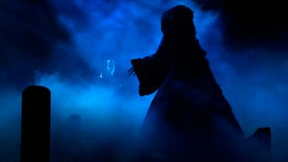 Szene aus einem Theaterstück: ein Geist im blauen Nebel.