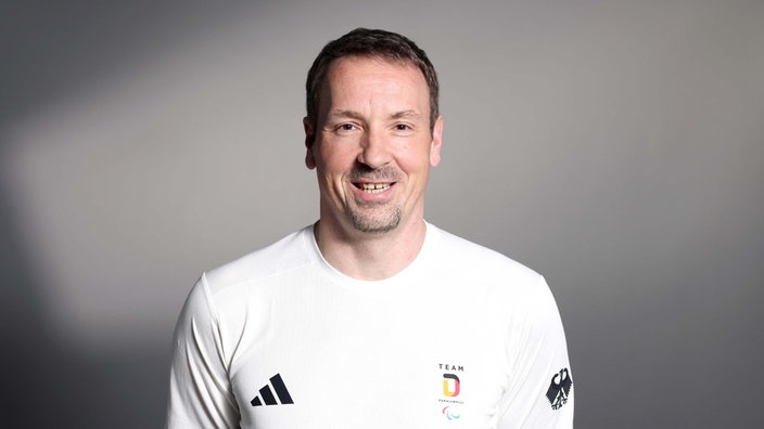 Jürgen Schrapp, Kapitän der deutschen Sitzvolleyballer, lächelt für ein Porträt in die Kamera. 