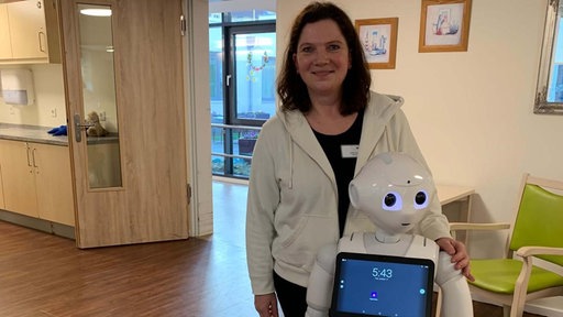 Pflegerin Jutta Tandler aus Lübeck mit Roboter "Charlie". 