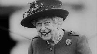Die alternde Queen Elizabeth II. mit typischem Hut lächelt.