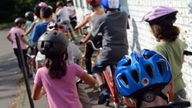 Ein Dutzend Viertklässler mit Fahrrädern und Schutzhelmen beim Verkehrsunterricht