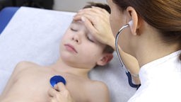 Eine Ärztin untersucht einen Jungen in der Praxis
