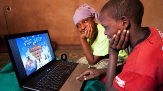 Zwwei Junge Tuareg Jungs spielen an einem Laptop.